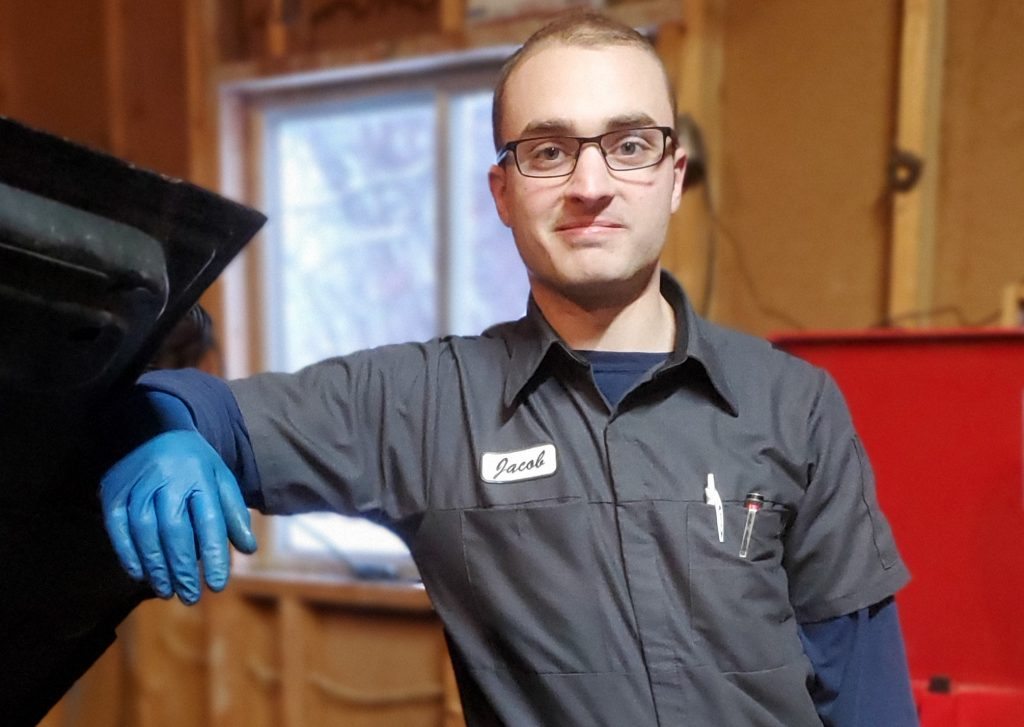 Green Light Automotive technician standing beside a vehicle